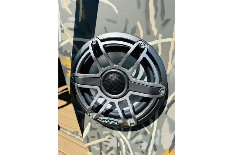 Slide: The Image of 2024 War Eagle 2170 Blackhawk boat with JL Audio speaker on camo-patterned surface. - 4