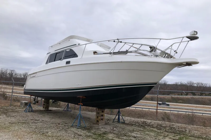 The Image of 1994 Mainship 31 Sedan Bridge boat on stands, outdoors, overcast sky. - 0