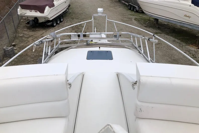 Slide: The Image of 1994 Mainship 31 Sedan Bridge boat deck view, featuring white seating and railing. - 2