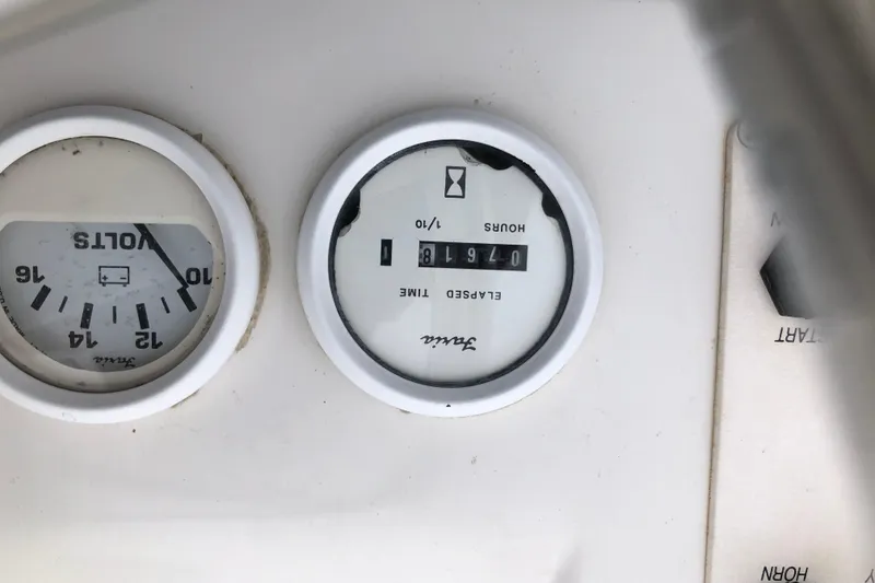 Slide: The Image of Close-up of Mainship 31 Sedan Bridge 1994 dashboard gauges showing volts and elapsed time. - 6