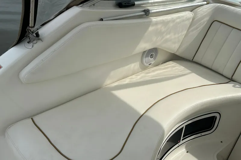 Slide: The Image of 2001 Sea Ray 270 Sundancer interior seating with white upholstery and speaker detail. - 10