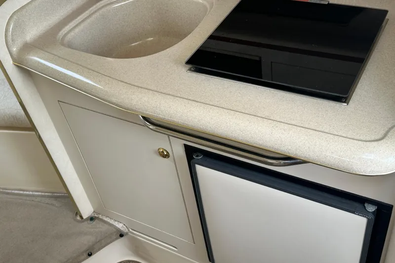 Slide: The Image of 2001 Sea Ray 270 Sundancer interior kitchenette with sink and stove. - 13
