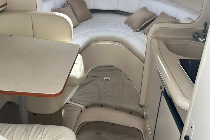 Slide: The Image of Interior of 2001 Sea Ray 270 Sundancer with seating, table, and kitchenette. - 14