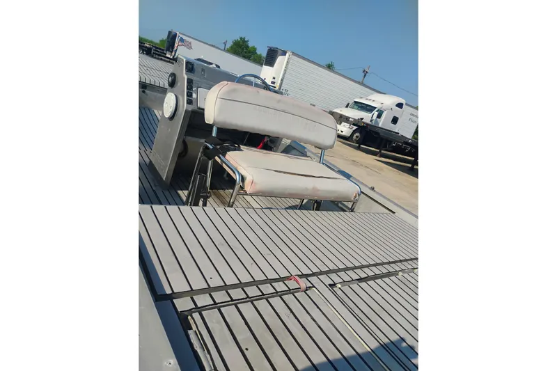 Slide: The Image of 2010 Hanko 20 SC boat interior with seating and control panel, parked near trucks. - 7