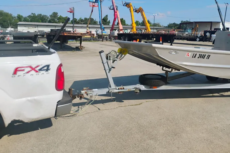 Slide: The Image of White truck towing a 2010 Hanko 20 SC boat on a trailer in an industrial area. - 8