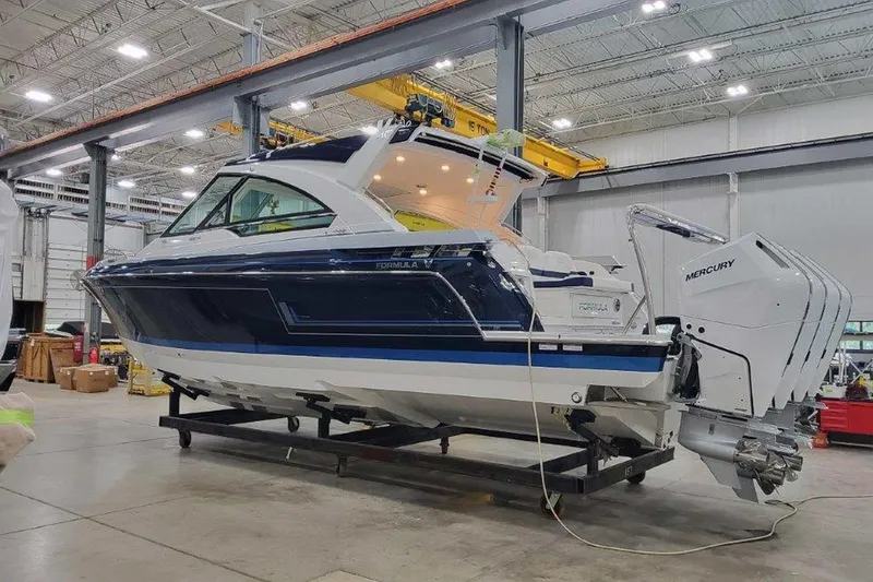 Slide: The Image of 2026 Formula 400 Super Sport Crossover boat in a showroom, featuring sleek design and Mercury engine. - 3