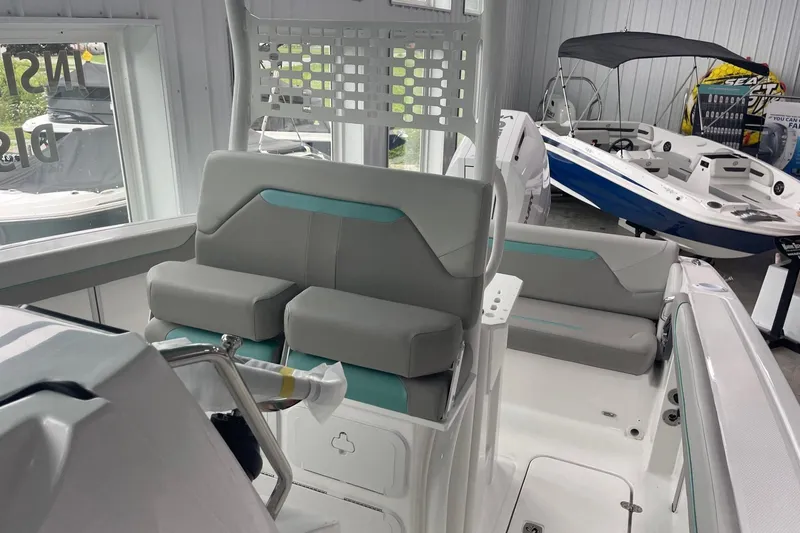 Slide: The Image of 2026 Hurricane Center Console 24 OB boat interior with modern seating in showroom. - 16