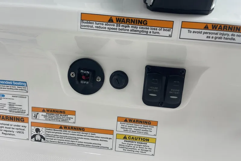 Slide: The Image of Control panel of 2026 Hurricane Center Console 24 OB with warning labels and battery switches. - 23