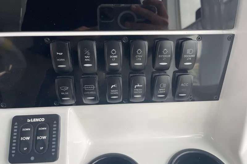 Slide: The Image of Control panel of 2026 Hurricane Center Console 24 OB boat with labeled switches and buttons. - 27
