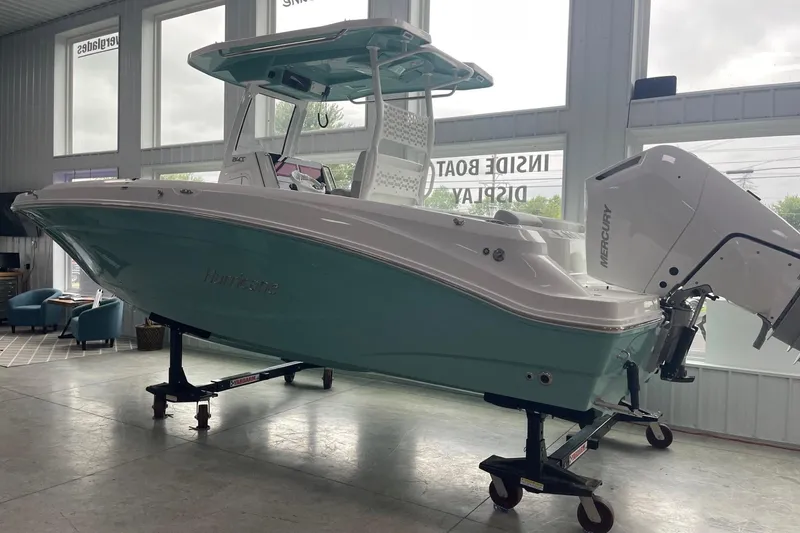 Slide: The Image of 2026 Hurricane Center Console 24 OB boat displayed indoors with Mercury outboard engine. - 3