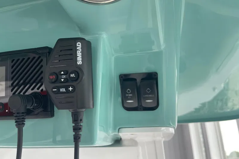 Slide: The Image of Control panel of 2026 Hurricane Center Console 24 OB with Simrad radio and switches. - 31