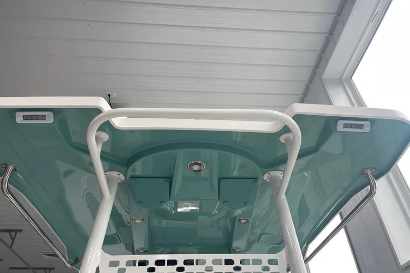 Slide: The Image of 2026 Hurricane Center Console 24 OB boat canopy, teal and white design, indoor setting. - 33