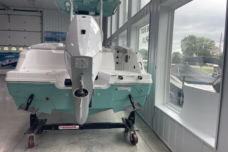 Slide: The Image of 2026 Hurricane Center Console 24 OB boat displayed indoors on a stand. - 5