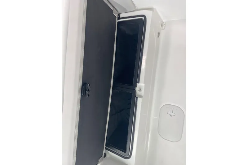 Slide: The Image of 2026 Hurricane Center Console 24 OB boat storage compartment, open with black interior. - 53