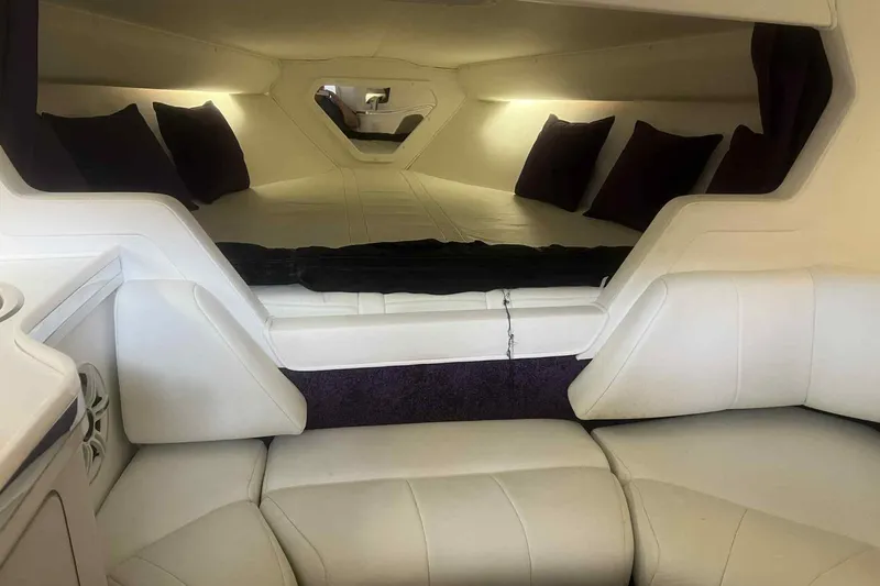 Slide: The Image of Interior of a 1997 Fountain 29 Fever boat with white seating and cozy sleeping area. - 2