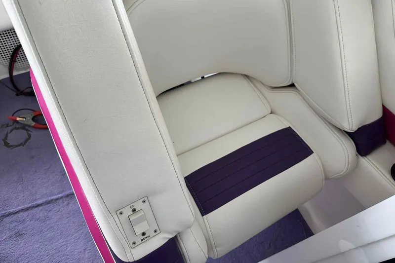 Slide: The Image of 1997 Fountain 29 Fever boat interior with white and purple seating, featuring an adjustable switch. - 20