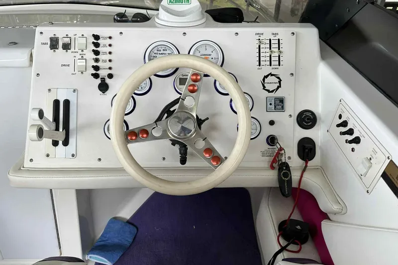 Slide: The Image of Steering wheel and dashboard of a 1997 Fountain 29 Fever boat with gauges and controls. - 21