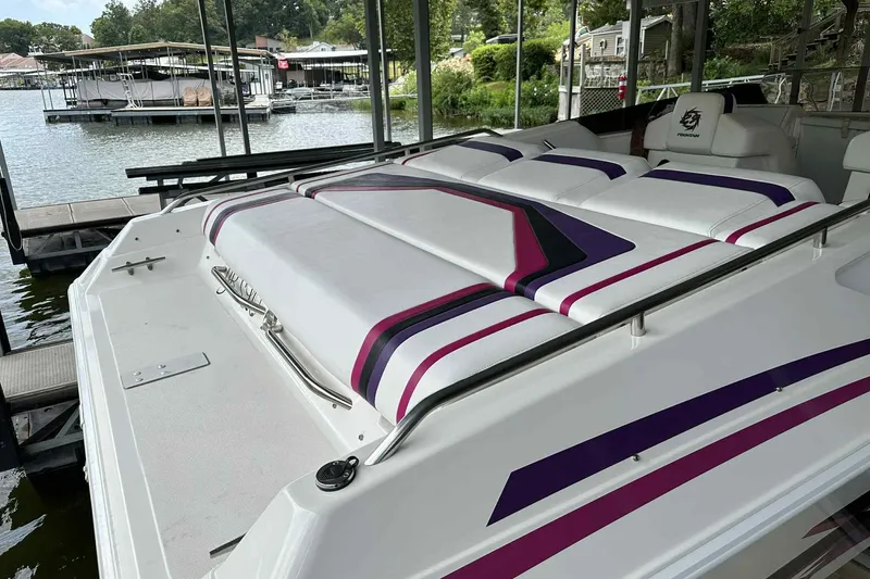 Slide: The Image of 1997 Fountain 29 Fever boat with vibrant upholstery docked by a serene lakeside. - 22