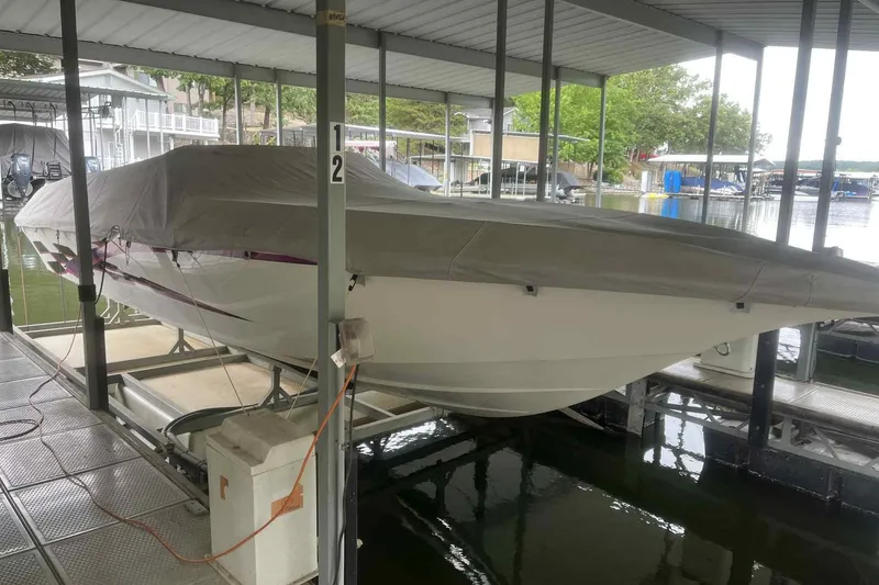 Slide: The Image of 1997 Fountain 29 Fever boat covered and docked in a marina. - 23