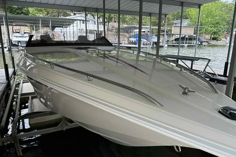 Slide: The Image of 1997 Fountain 29 Fever boat docked in a covered marina, surrounded by water and other boats. - 24