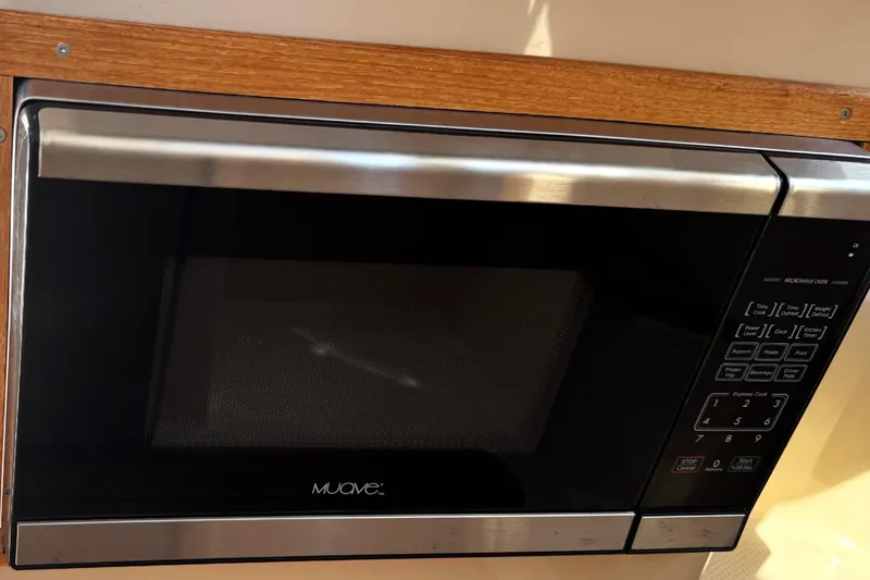 Slide: The Image of Built-in microwave in 2019 Ranger Tugs R-23 boat kitchen, featuring wood trim. - 11