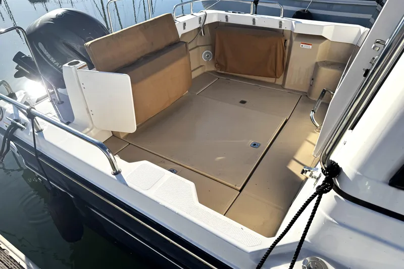 Slide: The Image of 2019 Ranger Tugs R-23 boat deck with seating and outboard motor. - 2