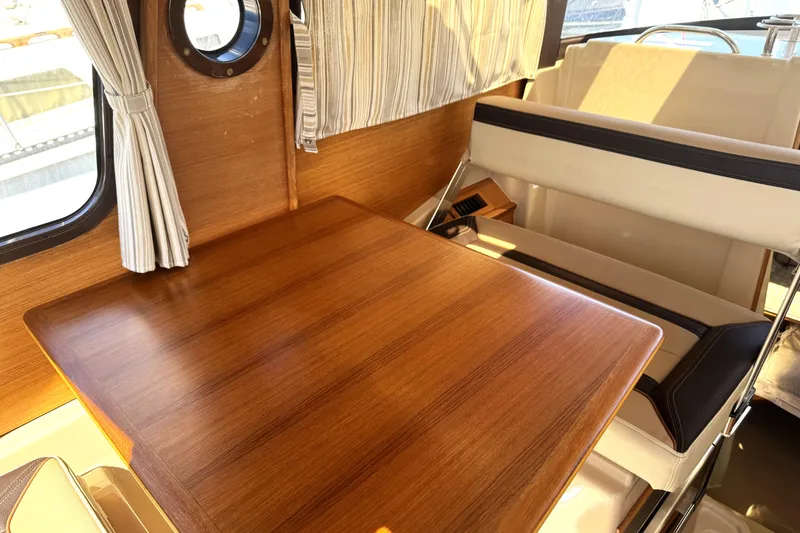 Slide: The Image of 2019 Ranger Tugs R-23 interior with wooden table and seating area. - 6