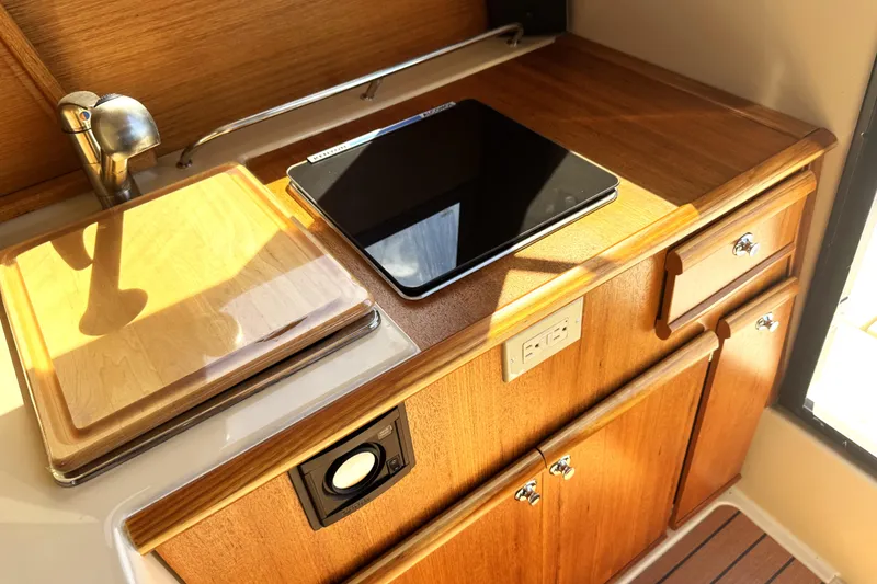 Slide: The Image of 2019 Ranger Tugs R-23 interior with wooden cabinetry and modern kitchen amenities. - 7