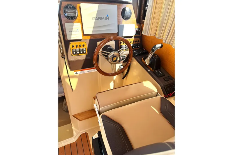 Slide: The Image of 2019 Ranger Tugs R-23 helm with Garmin navigation, wood accents, and comfortable seating. - 8