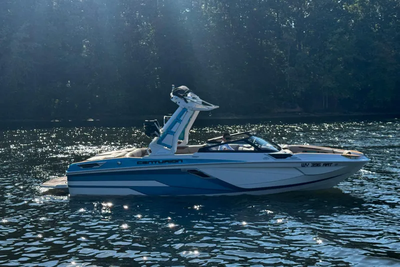 Slide: The Image of 2023 Centurion Ri230 boat on a sunny lake with forest background. - 10