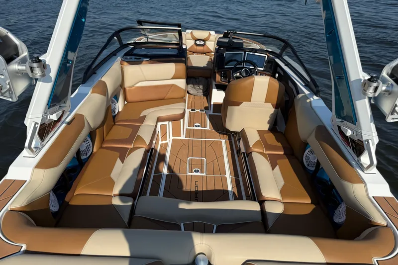 Slide: The Image of 2023 Centurion Ri230 boat interior with luxurious tan seating and modern dashboard. - 14