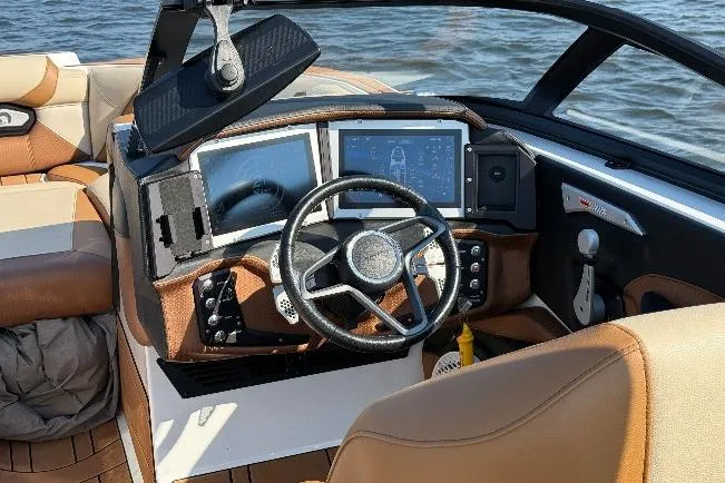 Slide: The Image of 2023 Centurion Ri230 boat dashboard with modern controls and steering wheel on water. - 19
