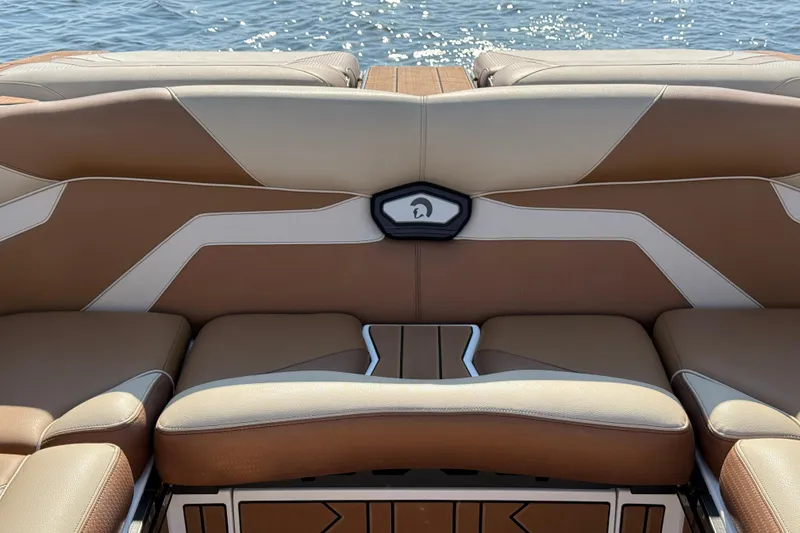 Slide: The Image of 2023 Centurion Ri230 boat interior with luxurious brown seating and water backdrop. - 22