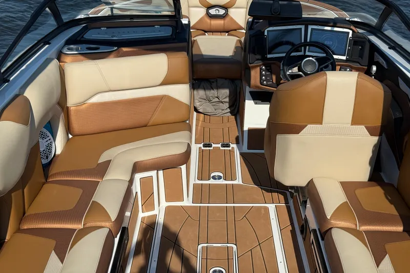 Slide: The Image of 2023 Centurion Ri230 boat interior with luxurious brown and beige seating and modern dashboard. - 25
