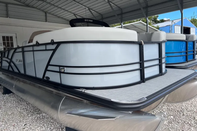 Slide: The Image of 2026 Sylvan MIRAGE 822 CLZ DH pontoon boat in a covered storage area. - 3