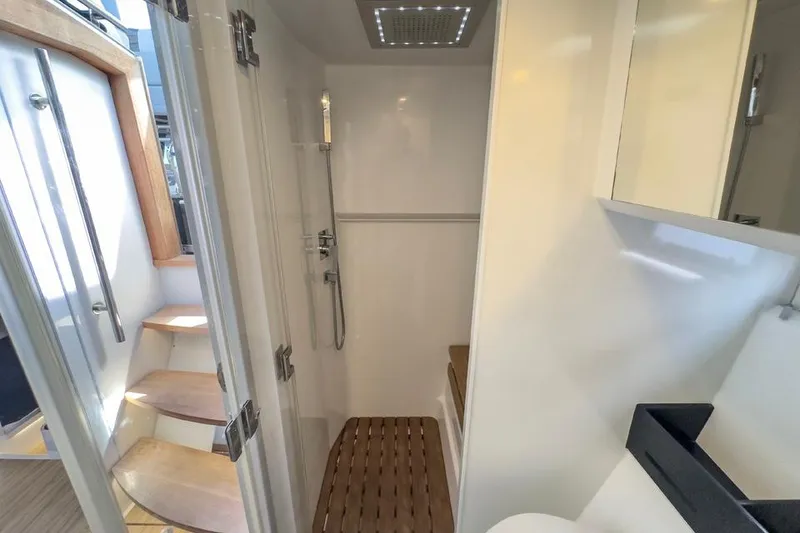 Slide: The Image of Interior of 2016 Fjord 48 Open yacht, featuring a modern shower and wooden steps. - 25