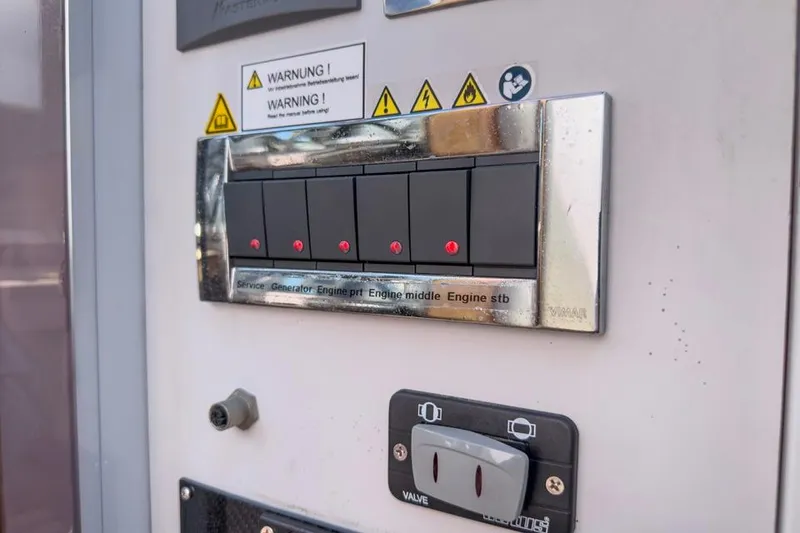 Slide: The Image of Control panel on a 2016 Fjord 48 Open boat with warning labels and switches. - 31