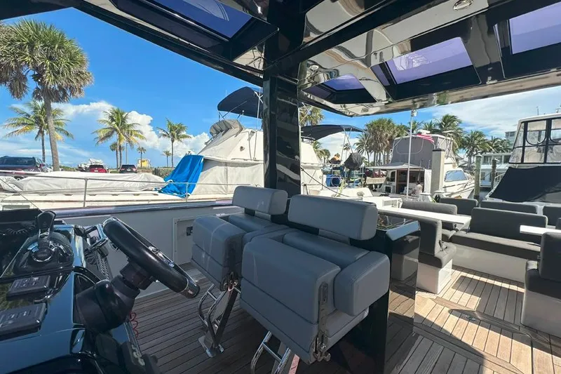 Slide: The Image of 2016 Fjord 48 Open yacht interior with modern seating and steering, docked at a marina. - 33