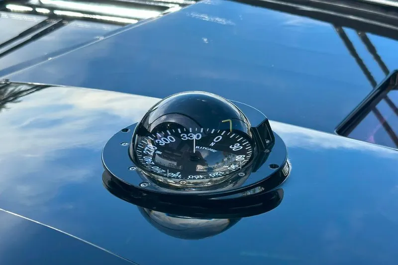 Slide: The Image of Compass on 2016 Fjord 48 Open yacht, reflecting sky and surroundings. - 43