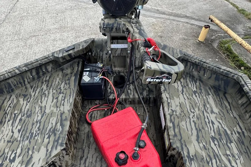 Slide: The Image of 2025 SeaArk 1752 Slayer Pro boat interior with camouflage design, battery, and fuel tank. - 10