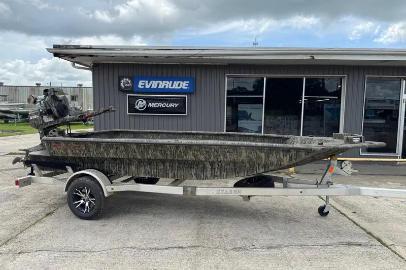 Slide: The Image of 2025 SeaArk 1752 Slayer Pro boat on trailer, parked outside dealership. - 2