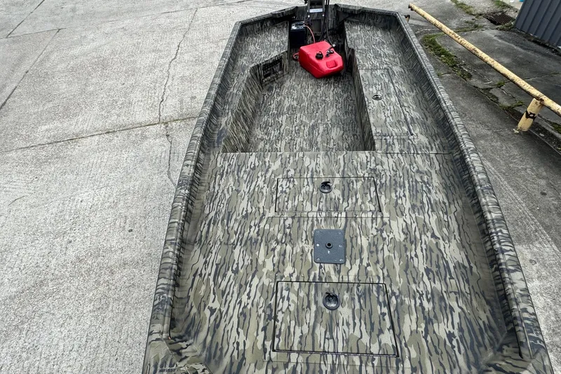 Slide: The Image of 2025 SeaArk 1752 Slayer Pro boat with camouflage design on concrete surface. - 6