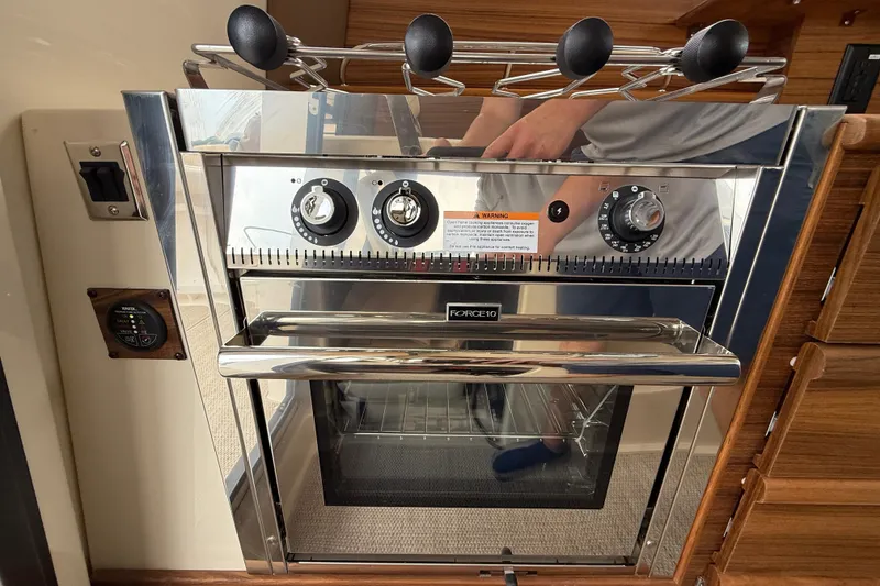 Slide: The Image of 2026 Ranger Tugs R-27 cruising on a lake with city skyline in background. - 10