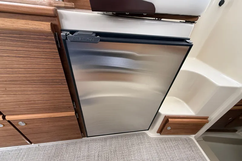 Slide: The Image of 2026 Ranger Tugs R-27 cruising on a scenic lake with city skyline backdrop. - 11