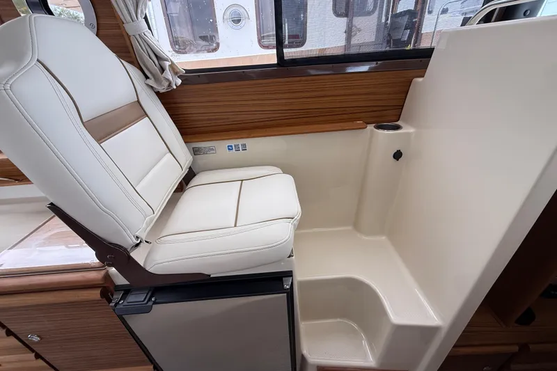 Slide: The Image of 2026 Ranger Tugs R-27 boat interior with seating and kitchen area. - 15