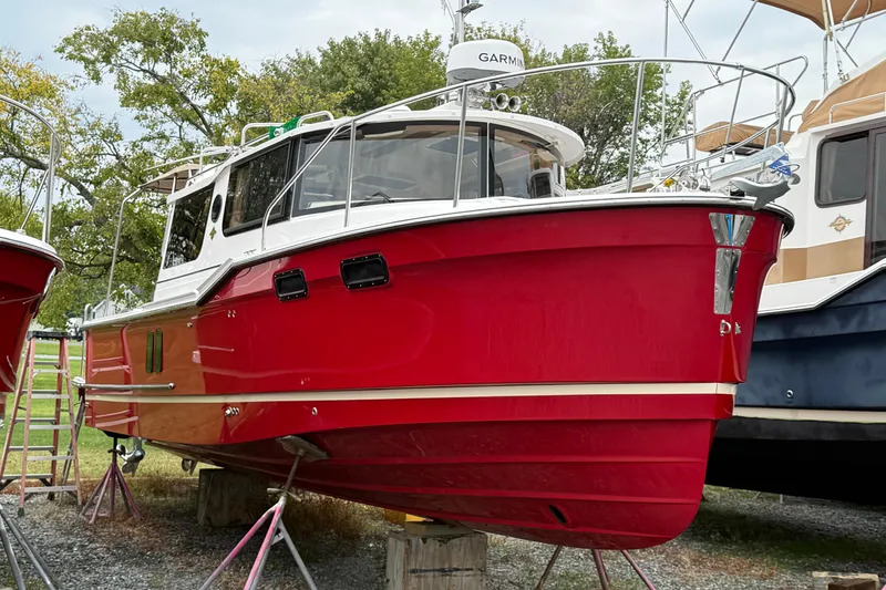 The Image of 2026 Ranger Tugs R-27 cruising on a scenic lake with forested background. - 2