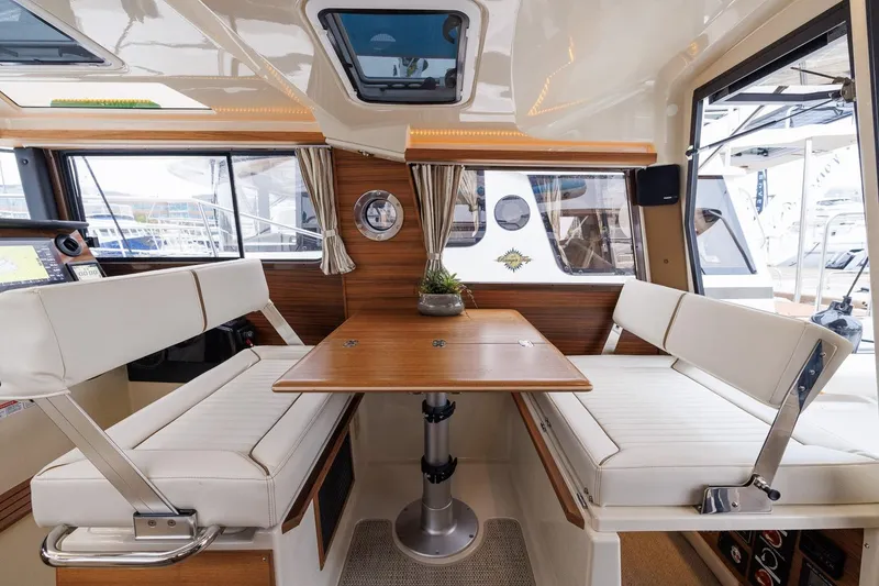 Slide: The Image of Interior of 2026 Ranger Tugs R-27 with dining area and panoramic windows. - 21