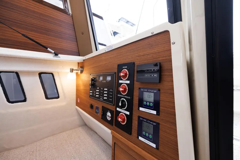 Slide: The Image of 2026 Ranger Tugs R-27 interior with control panel and cozy cabin lighting. - 22