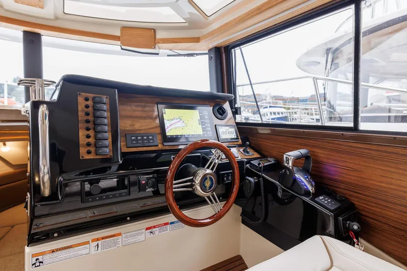 Slide: The Image of Helm of 2026 Ranger Tugs R-27 with navigation equipment and wooden accents. - 23