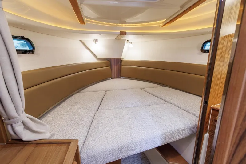 Slide: The Image of 2026 Ranger Tugs R-27 interior cabin with cozy seating and elegant lighting. - 25